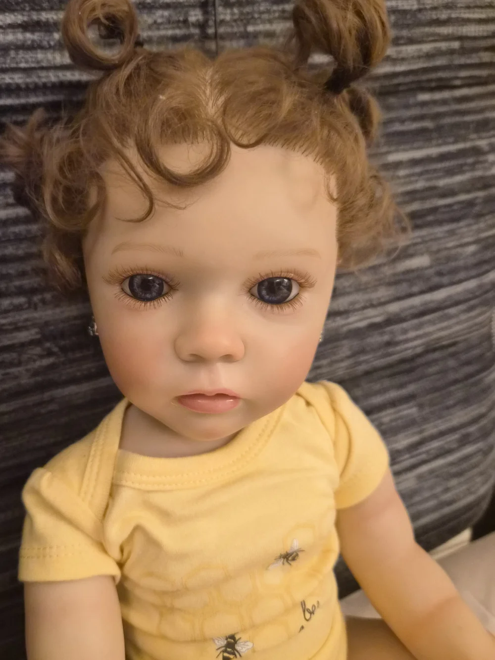 Reborn Baby Doll in Yellow Onesie with Curly Brown Hair